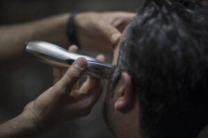 Barber cleans up edges on sideburns